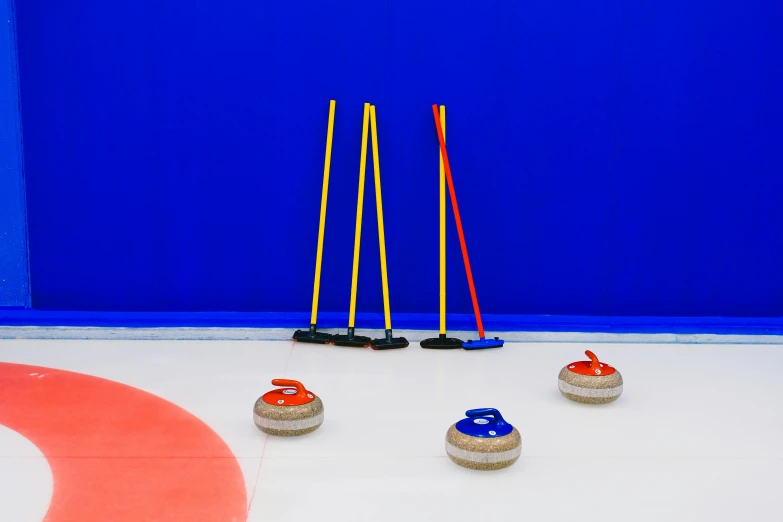 a group of curling stones sitting on top of an ice rink, by Julia Pishtar, cobalt blue and pyrrol red, sweeping, bowl, synthetic materials