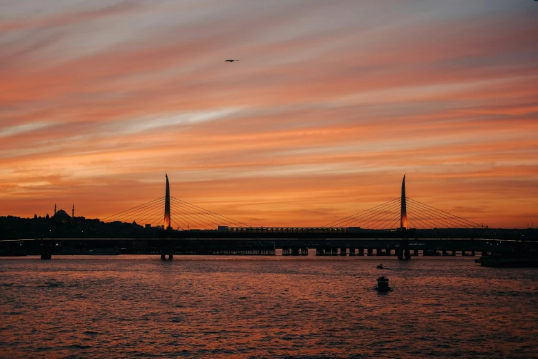 a large body of water with a bridge in the background, by Jan Tengnagel, pexels contest winner, hurufiyya, orange dawn, sky line, fan favorite, soaring towers and bridges