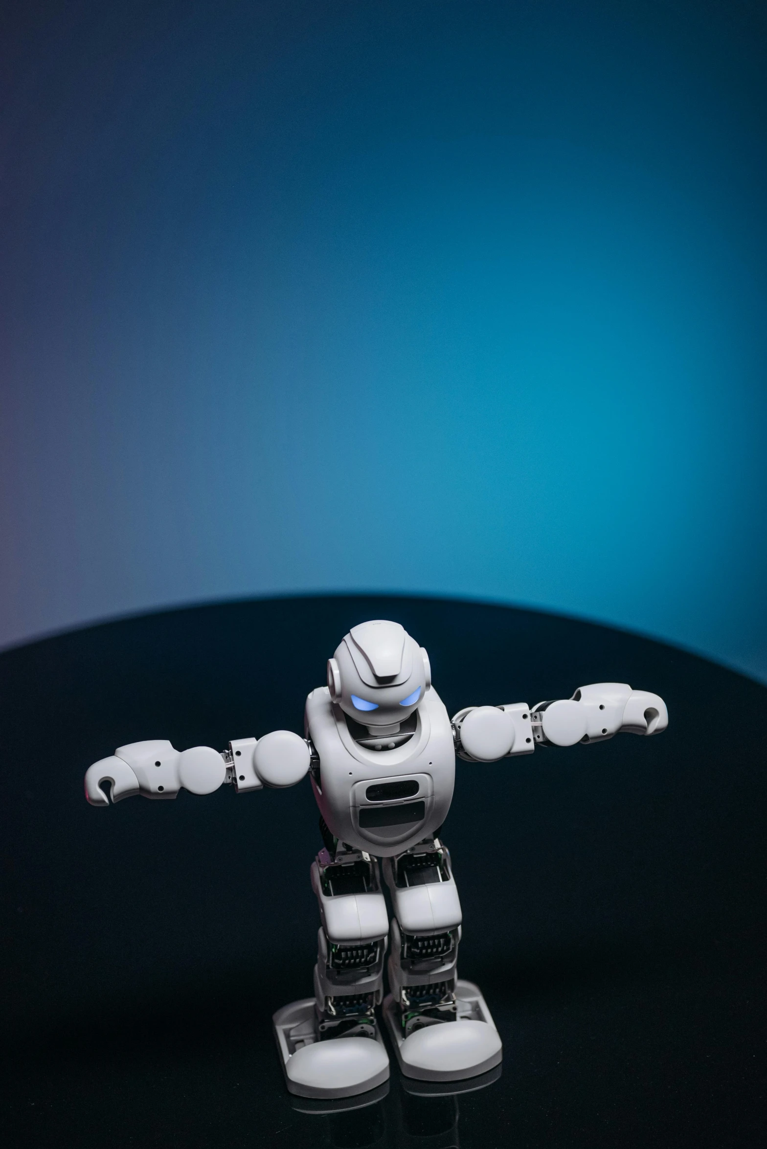 a close up of a toy robot on a table, trending on reddit, holography, plain background, photographed for reuters, with arms up, a high angle shot