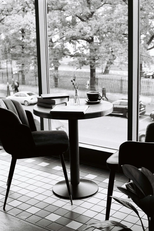 a black and white photo of a table and chairs, purism, drinking a coffee, looking outside, uploaded, high-quality photo