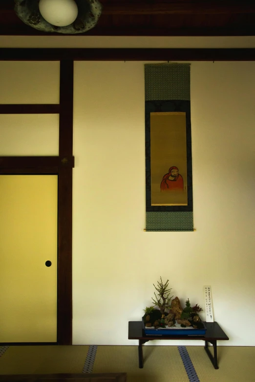 a room with a table and a painting on the wall, a minimalist painting, inspired by Sesshū Tōyō, flickr, sōsaku hanga, center frame portrait, pine, color photograph, masterpiece on a scroll