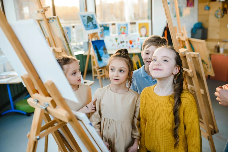 a group of children standing in front of easels, pexels contest winner, trending on artstion, thumbnail, fan favorite, looking across the shoulder