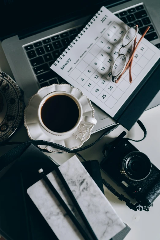 a laptop computer sitting on top of a desk next to a cup of coffee, a black and white photo, pexels contest winner, knolling, cameras lenses, ilustration, monthly