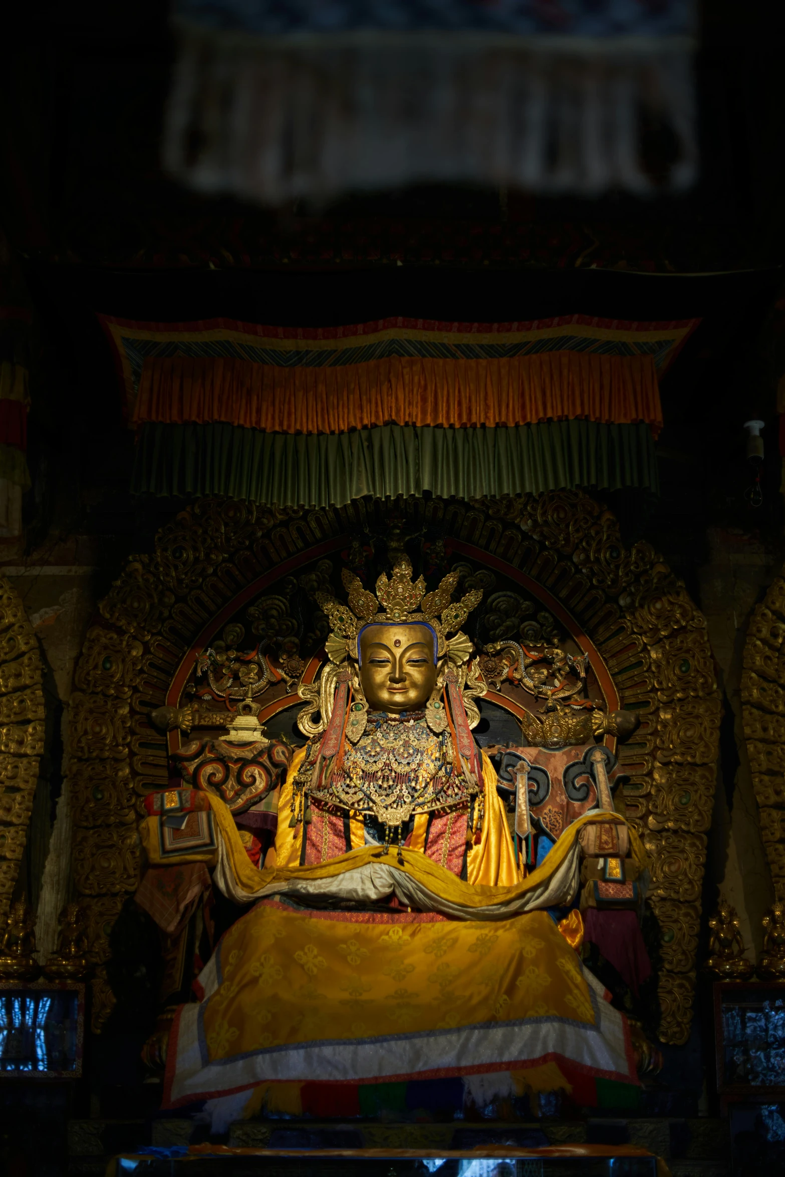 a statue that is inside of a building, sitting on a golden throne, during the night, omar shanti himalaya tibet, slide show