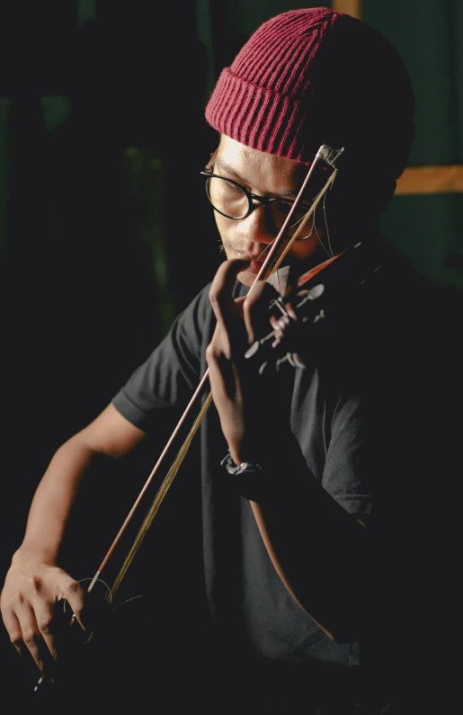 a man in a red hat playing a violin, an album cover, by Basuki Abdullah, pexels, profile pic, ebony, avatar image, brown