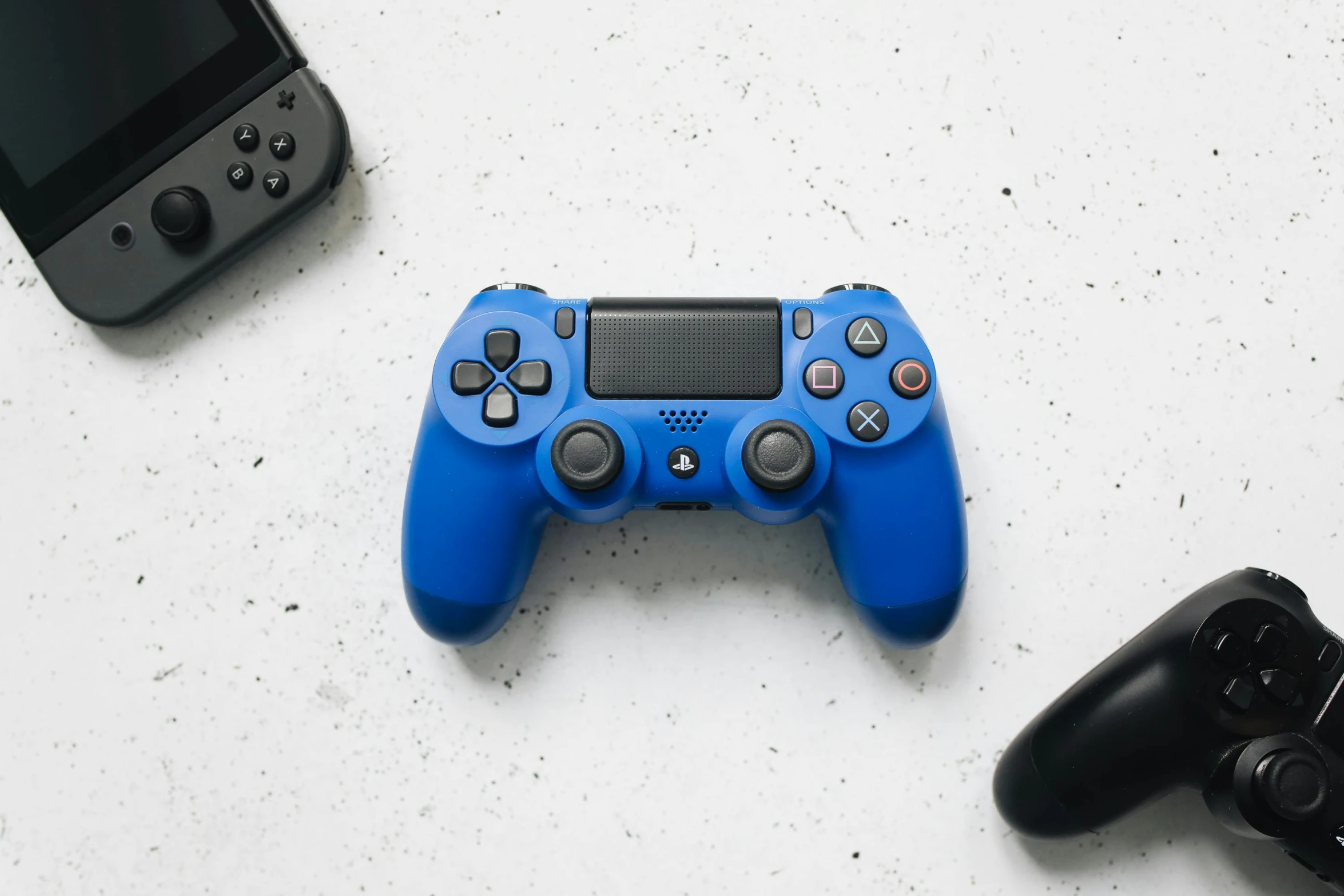 a couple of video game controllers sitting next to each other, unsplash, minimalism, wearing blue, on a white table, sony produced, 🦩🪐🐞👩🏻🦳