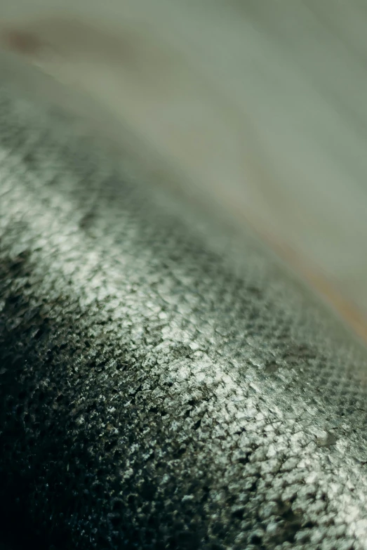 a close up of a fish on a table, an album cover, unsplash, photorealism, carbon fibers, hdr fabric textures, glistening seafoam, gray canvas