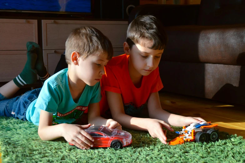 two boys laying on the floor playing with toy cars, a picture, pexels contest winner, figuration libre, starting engines nitro jet drive, bionicle, maxim sukharev, youtube thumbnail