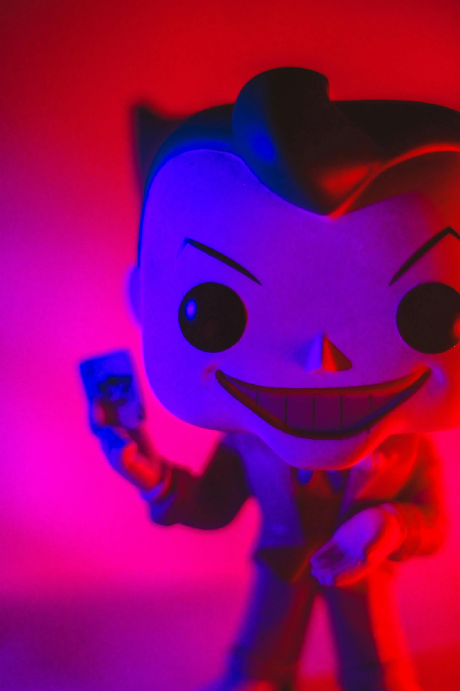 a close up of a batman pop vinyl figure, a hologram, pexels, pop art, pauline hanson as the joker, blue and red lighting, shaco from league of legends, small red lights