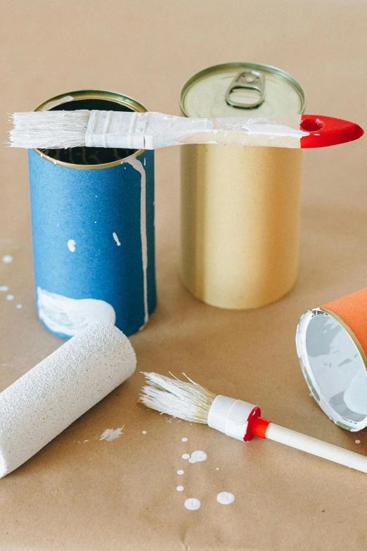 a couple of cans sitting on top of a table, inspired by James Rosenquist, unsplash, process art, long paint brush strokes, brushed white and blue paint, bright construction materials, thumbnail