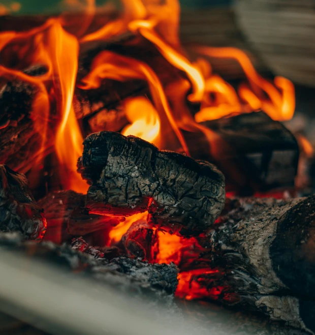 a close up of a fire in a grill, pexels contest winner, cozy environment, a wooden, vivid ember colors, subtle details