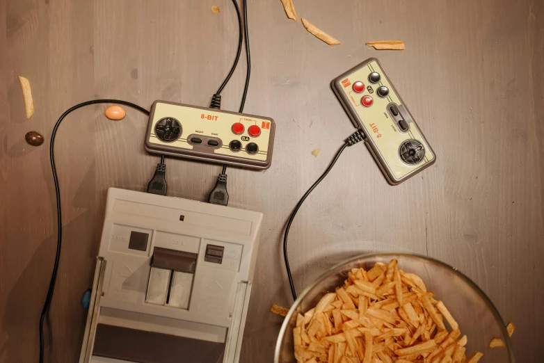 a bowl of food sitting on top of a wooden table, an album cover, twins playing video games, usb ports, circuit, fries