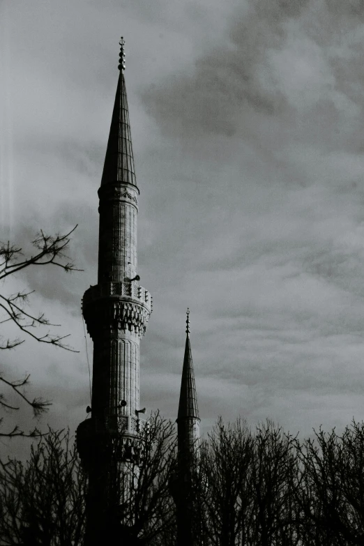 a black and white photo of a tall tower, inspired by Altoon Sultan, hurufiyya, tall spires, desaturated color, album cover, 1999 photograph