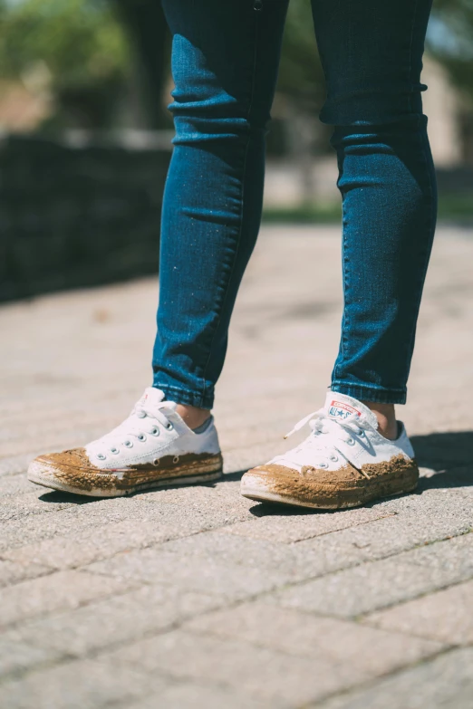 a person standing on a sidewalk with their feet on a skateboard, by Julia Pishtar, trending on pexels, renaissance, covered in dirt, white shoes, made of bamboo, fungal pages