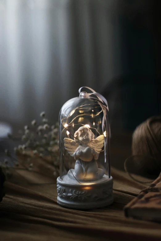 a light that is sitting on top of a table, inspired by Ida Rentoul Outhwaite, resin miniature, festive atmosphere, grey, warmly lit