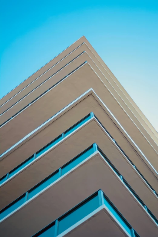 a tall building with a blue sky in the background, brown and cyan color scheme, up-close, square, high-quality photo