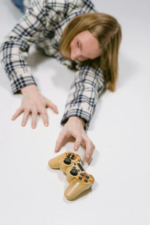 a woman laying on the floor next to a video game controller, inspired by Sarah Lucas, unsplash, hyperrealism, on white background, scary pose, hand on table, falling