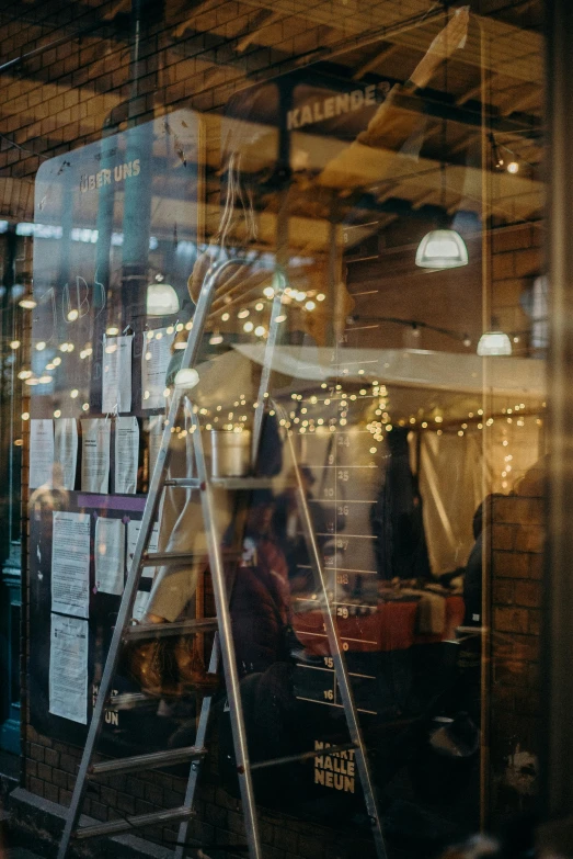 a person standing in front of a store window, trending on unsplash, renaissance, ladders, fairy lights, maintenance photo, busy restaurant