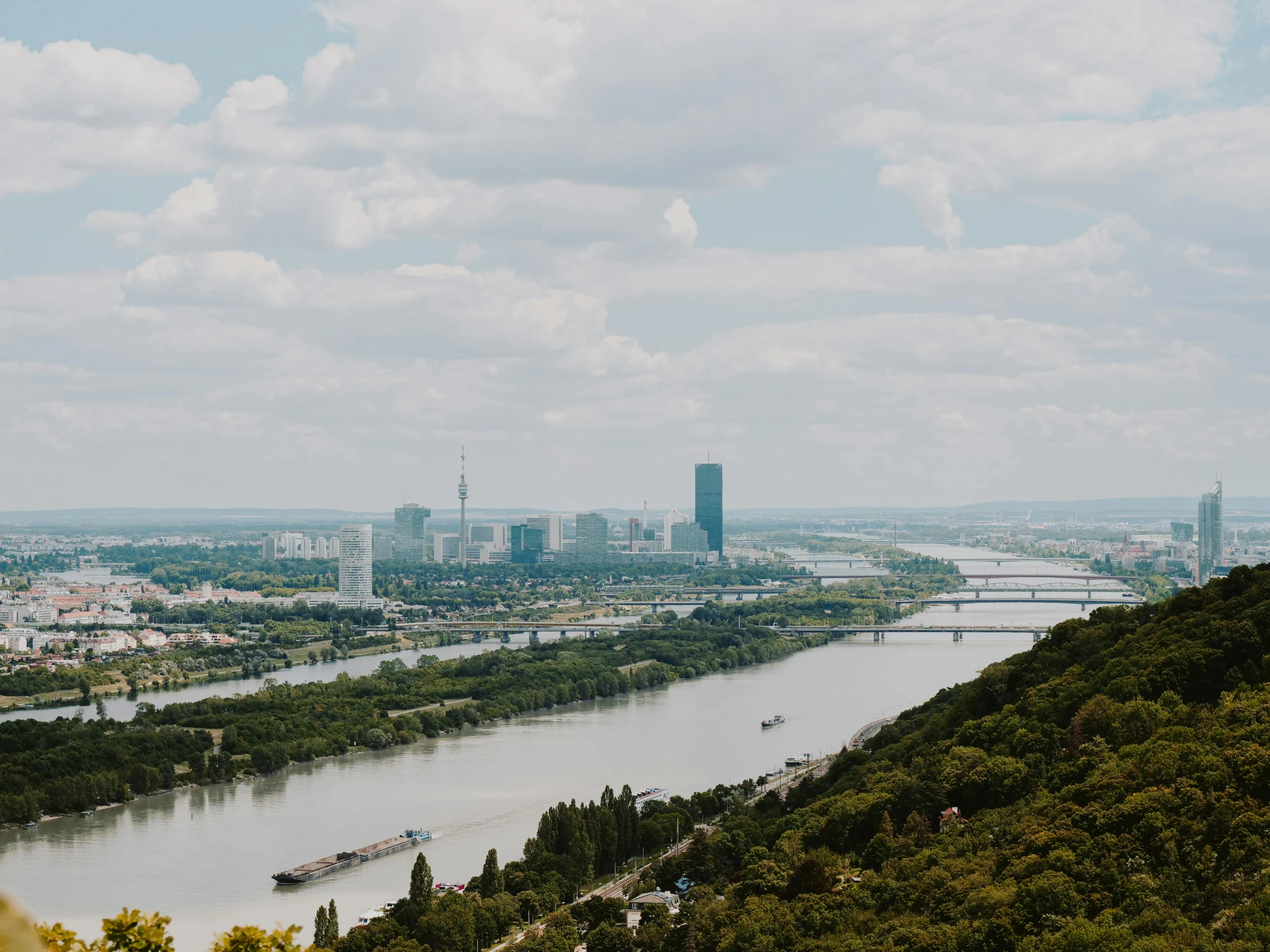 a view of a city from the top of a hill, pexels contest winner, viennese actionism, scenic view of river, thumbnail, river and trees and hills, mies van der rohe