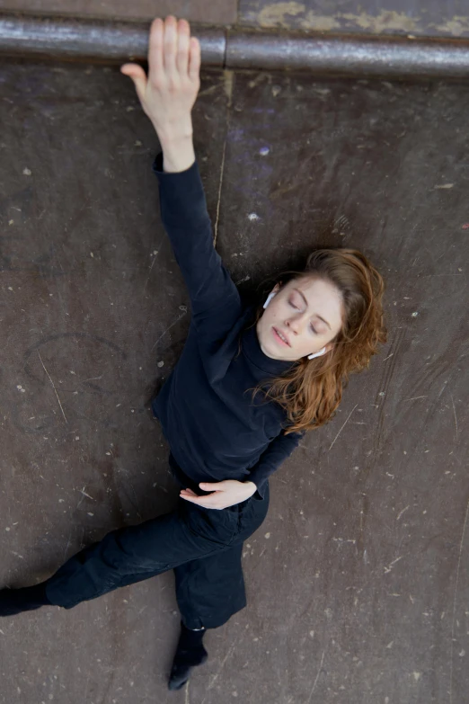 a woman standing on top of a skateboard ramp, inspired by Elizabeth Polunin, unsplash, renaissance, lying pose on stones, looking down from above, miranda otto, seen from above