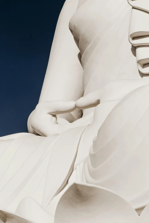 a large white statue sitting on top of a lush green field, a marble sculpture, unsplash, minimalism, closeup of fist, buddhist architecture, frank gehry, detailed close foot shot