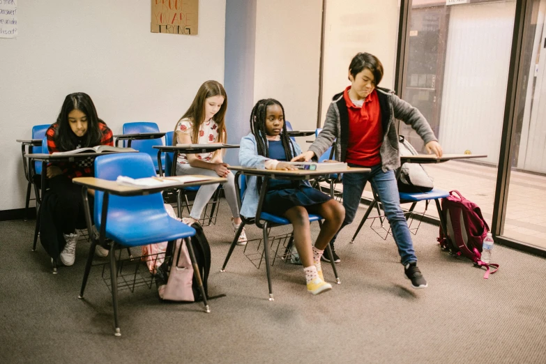 a group of children sitting at desks in a classroom, pexels contest winner, sitting on a mocha-colored table, future coder looking on, janice sung, riyahd cassiem