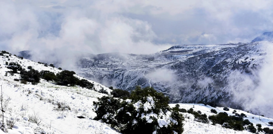 a man riding skis down a snow covered slope, by Lucia Peka, pexels contest winner, les nabis, cyprus, covered in clouds, seen from afar, spring winter nature melted snow