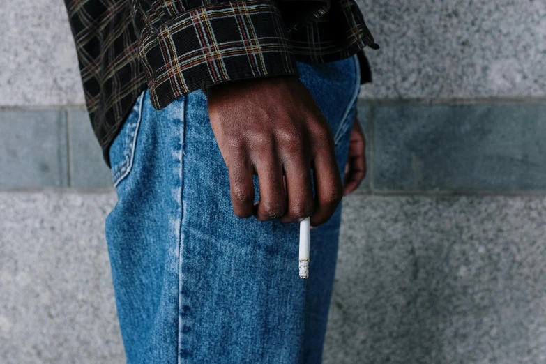 a man with a cigarette in his pocket, by Nina Hamnett, trending on unsplash, black teenage boy, blue jeans, realistic hand, ignant