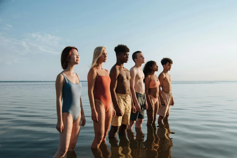 a group of people standing in the water, by Carey Morris, antipodeans, warm skin tone, full cast, looking onto the horizon, coloured