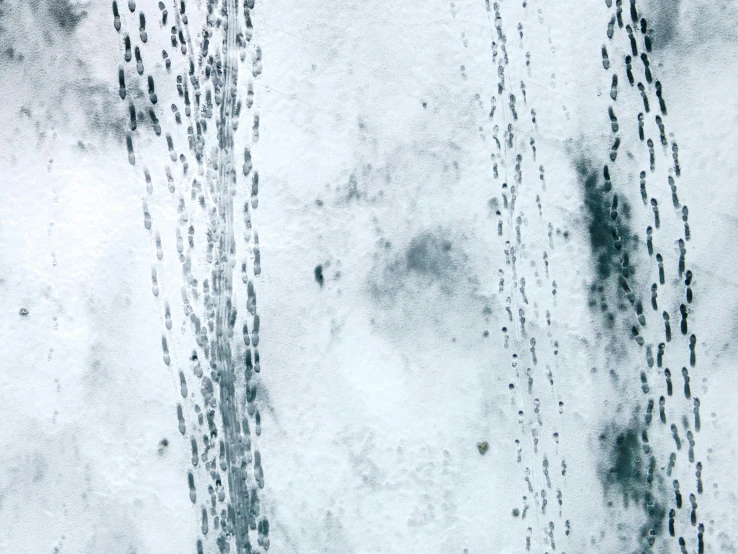 a man riding a snowboard down a snow covered slope, an abstract drawing, inspired by Vija Celmins, unsplash, lyrical abstraction, raindrops, satellite view, grungy steel, still from film