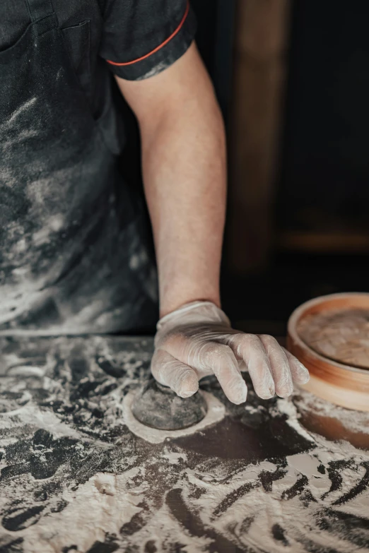 a man is making a bowl out of clay, a charcoal drawing, by Elizabeth Durack, trending on unsplash, bakery, sweat, marbling, gloves on hands