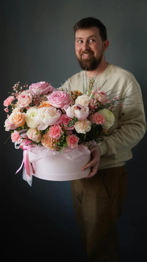 a man holding a large bouquet of flowers, a pastel, inspired by François Boquet, pexels contest winner, covered with pink marzipan, angle view, seasonal, detailed and soft