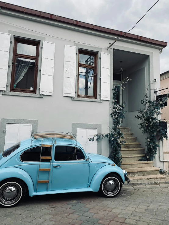 a blue car parked in front of a house, a photo, pexels contest winner, 🦩🪐🐞👩🏻🦳, greek style, white grey blue color palette, beetle