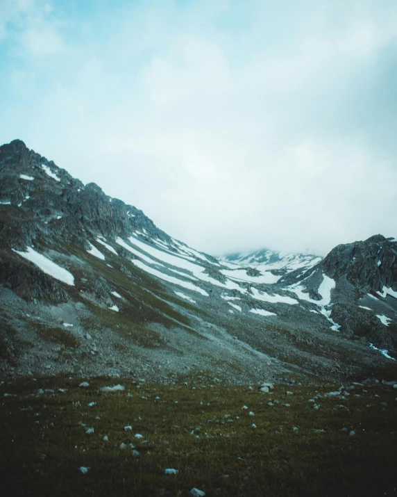 a mountain covered in snow on a cloudy day, an album cover, unsplash contest winner, highlands, grainy quality, low quality photo, tourist photo