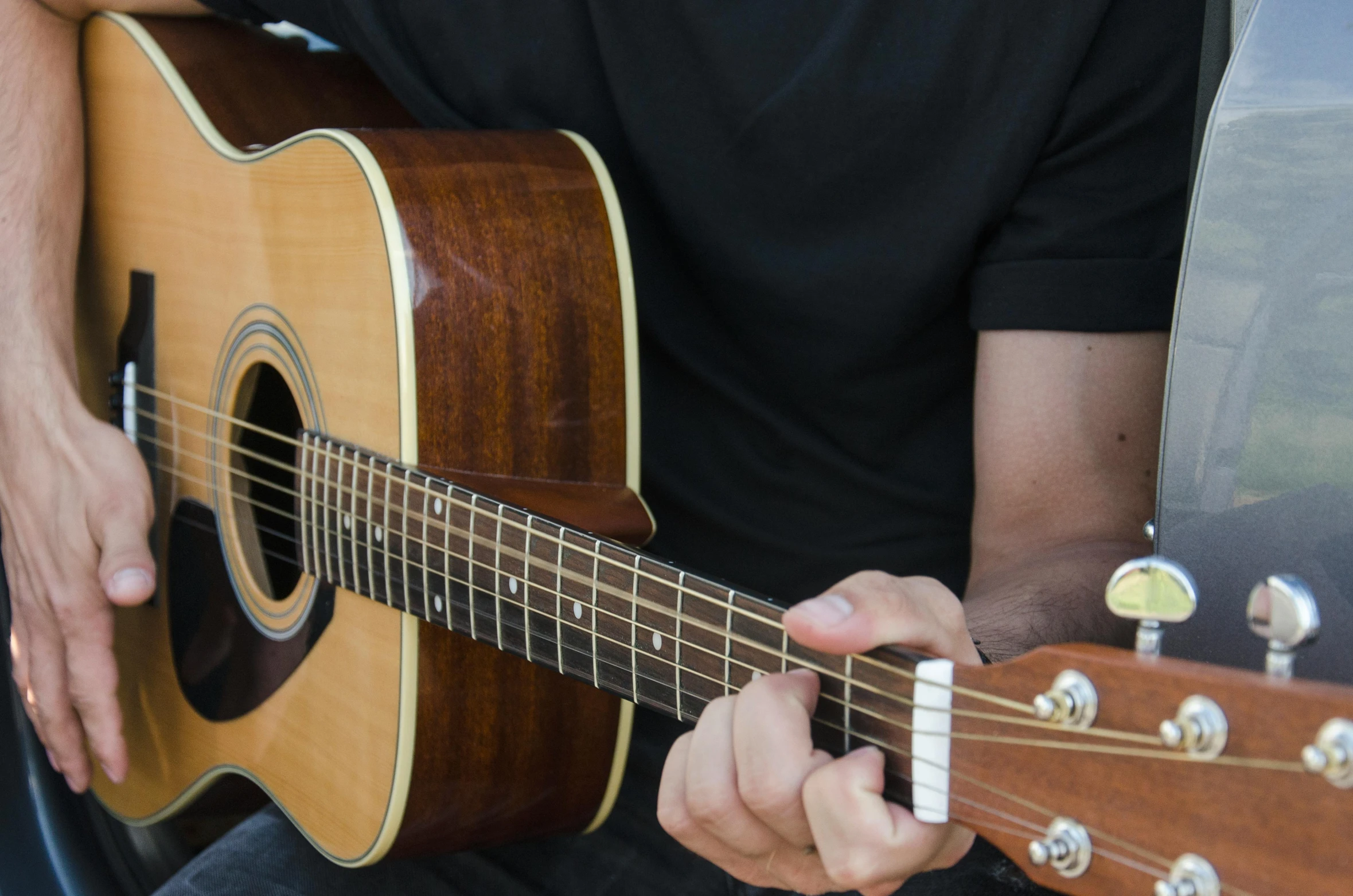 a close up of a person playing a guitar, holding a guitar