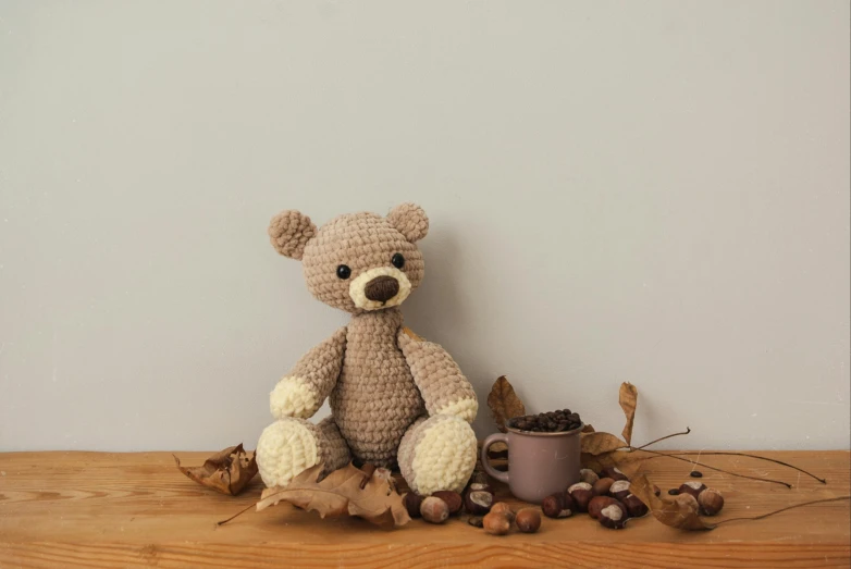 a teddy bear sitting on top of a wooden table, by Emma Andijewska, hurufiyya, beige cream natural muted tones, small, thumbnail, autumnal