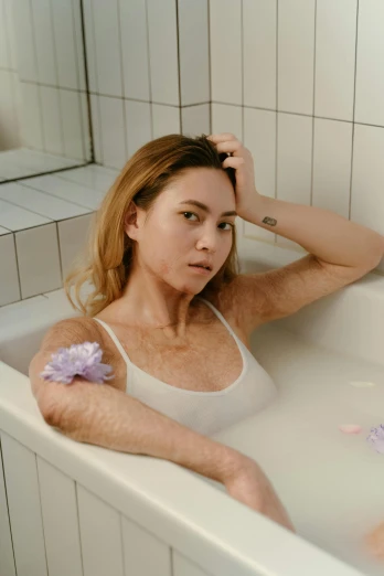 a woman sitting in a bathtub brushing her hair, a colorized photo, inspired by Elsa Bleda, trending on pexels, white freckles, flower, annoyed, furr covering her chest