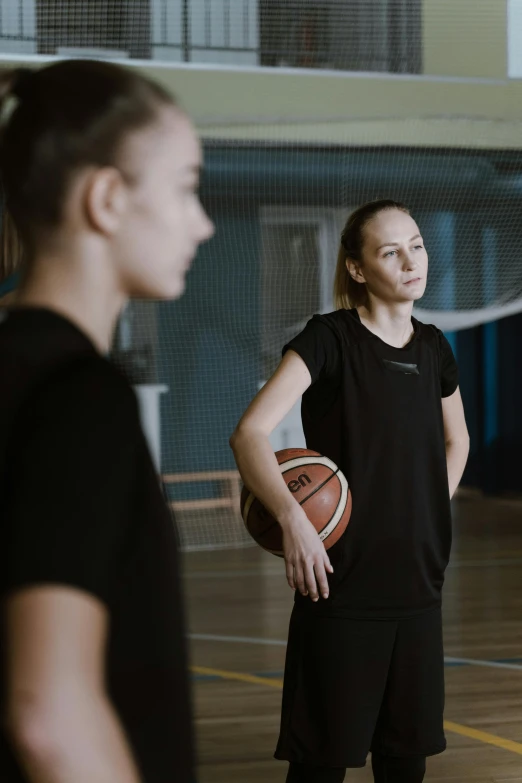 a group of young women standing on top of a basketball court, a portrait, by Adam Marczyński, wearing a black shirt, instruction, looking serious, olga zakharova