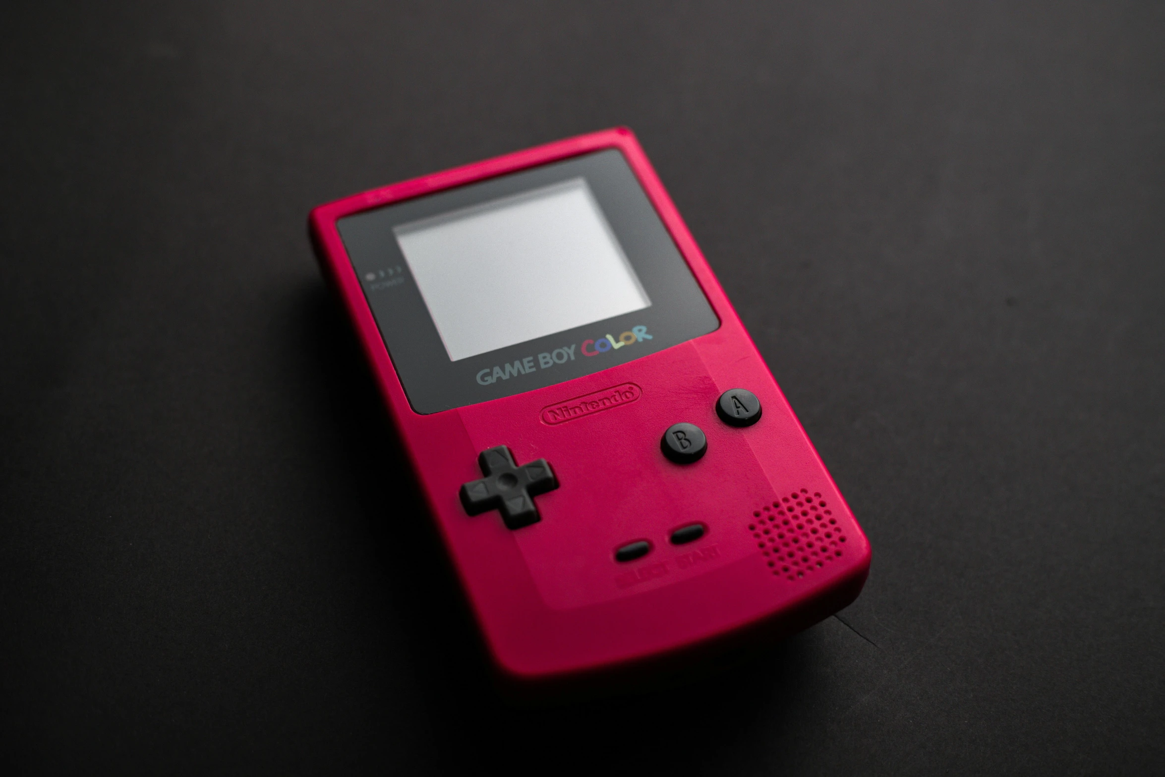 a red gameboy sitting on top of a table, pink, smooth technology, high quality product photography, monochrome