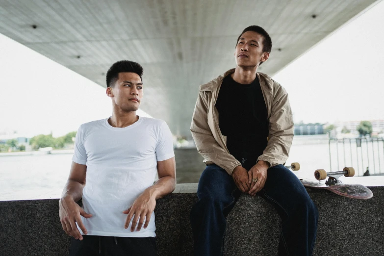 a couple of men sitting next to each other, pexels contest winner, asian descent, wearing pants and a t-shirt, bridges, ( ( theatrical ) )