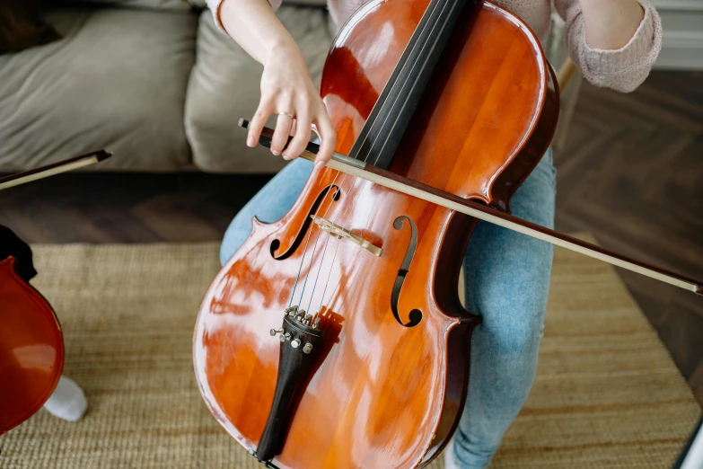 a woman sitting on a couch playing a cello, trending on pexels, avatar image, high angle close up shot, schools, rectangle