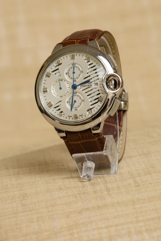 a close up of a watch on a table, by David Simpson, white with chocolate brown spots, cartier style, thumbnail, front angle