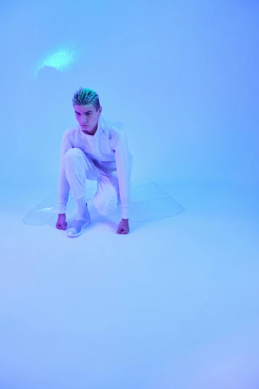 a man kneeling on top of a snow covered ground, an album cover, inspired by Elsa Bleda, trending on pexels, wearing futuristic white suit, brightly lit blue room, non binary model, justin bieber