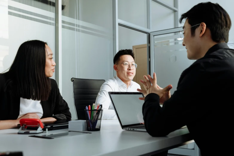 a group of people sitting around a table with laptops, a cartoon, by Simon Gaon, unsplash, asian man, scolding, high quality photo, ignant