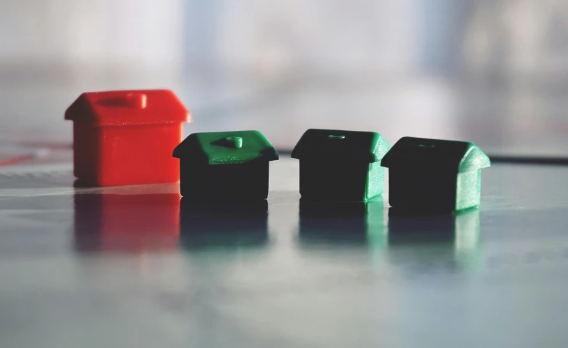 a row of toy houses sitting on top of a table, unsplash, red green black teal, square, emerald, home