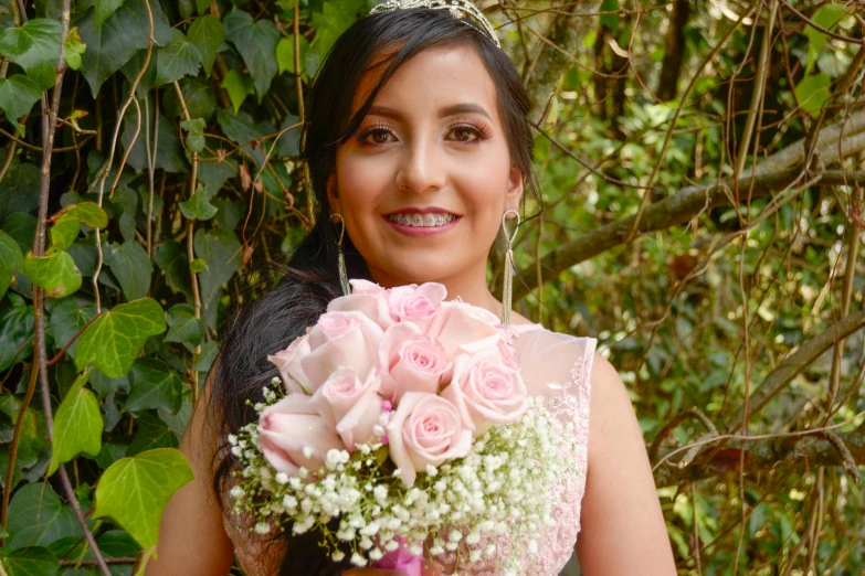 a woman in a wedding dress holding a bouquet of flowers, by reyna rochin, pexels, beautiful mexican woman, dressed in a pink dress, around 20 yo, professional photo-n 3