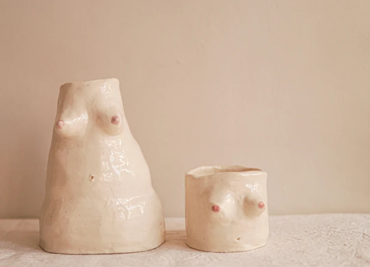 a couple of vases sitting on top of a table, inspired by Tracey Emin, feminist art, small breasts, large pores, with a white muzzle, fingerprints on clay