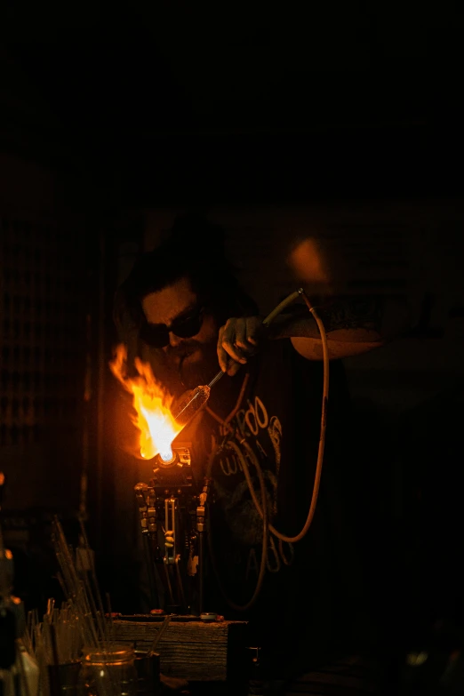 a man that is standing in the dark, kinetic art, smoking soldering iron, he is in a alchemist lab, pulling the move'derp banshee ', production photo