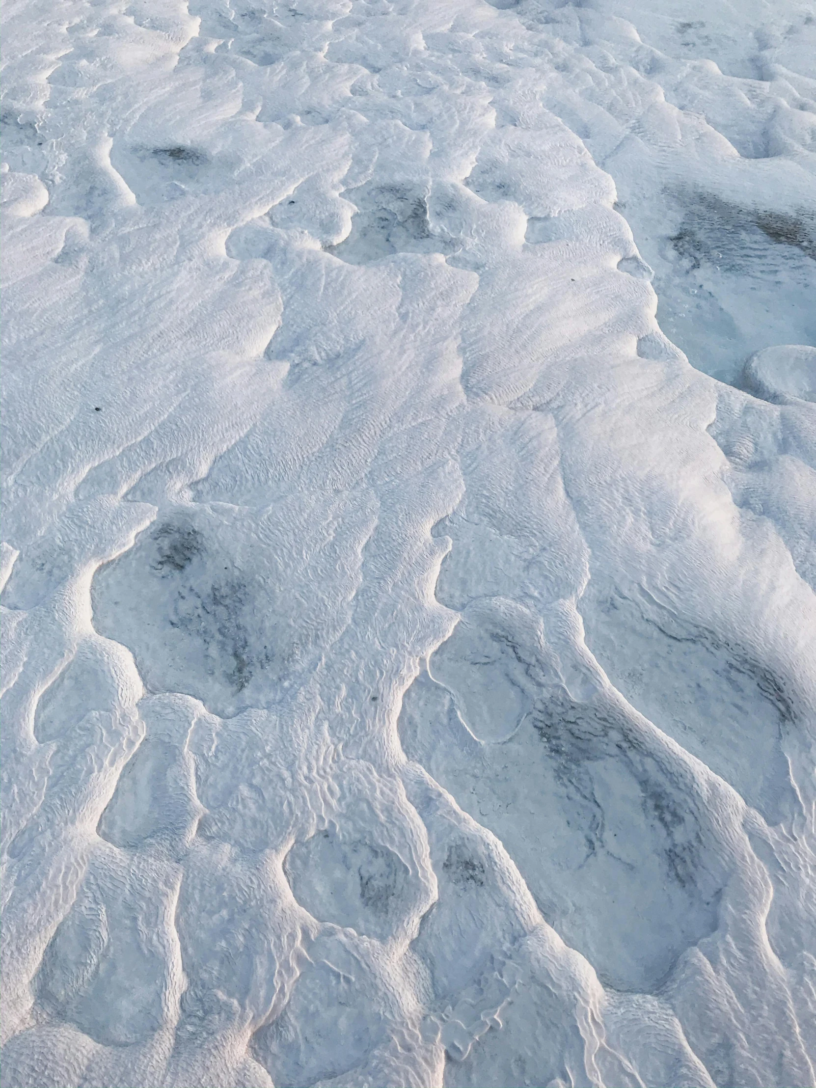 a red fire hydrant sitting on top of a snow covered field, an ultrafine detailed painting, trending on unsplash, the face emerges from pamukkale, aerial iridecent veins, covered in white flour, nasa true color 8k image