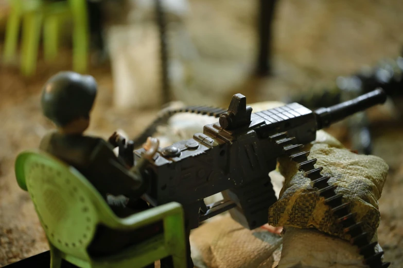 a toy soldier sitting in a chair with a machine gun, by Daniel Lieske, pexels contest winner, vietnam door gunner, legos, tabletop gaming, detail on scene
